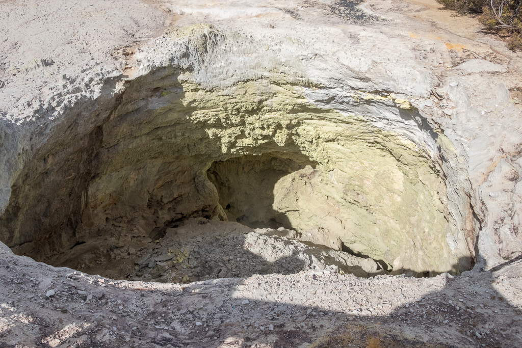The first example of a collapsed crater where underground acid action has caused the ground to collapse. Note the rough sides and yellow/greenish colours where cooling volcanic vapours have coloured the walls.
